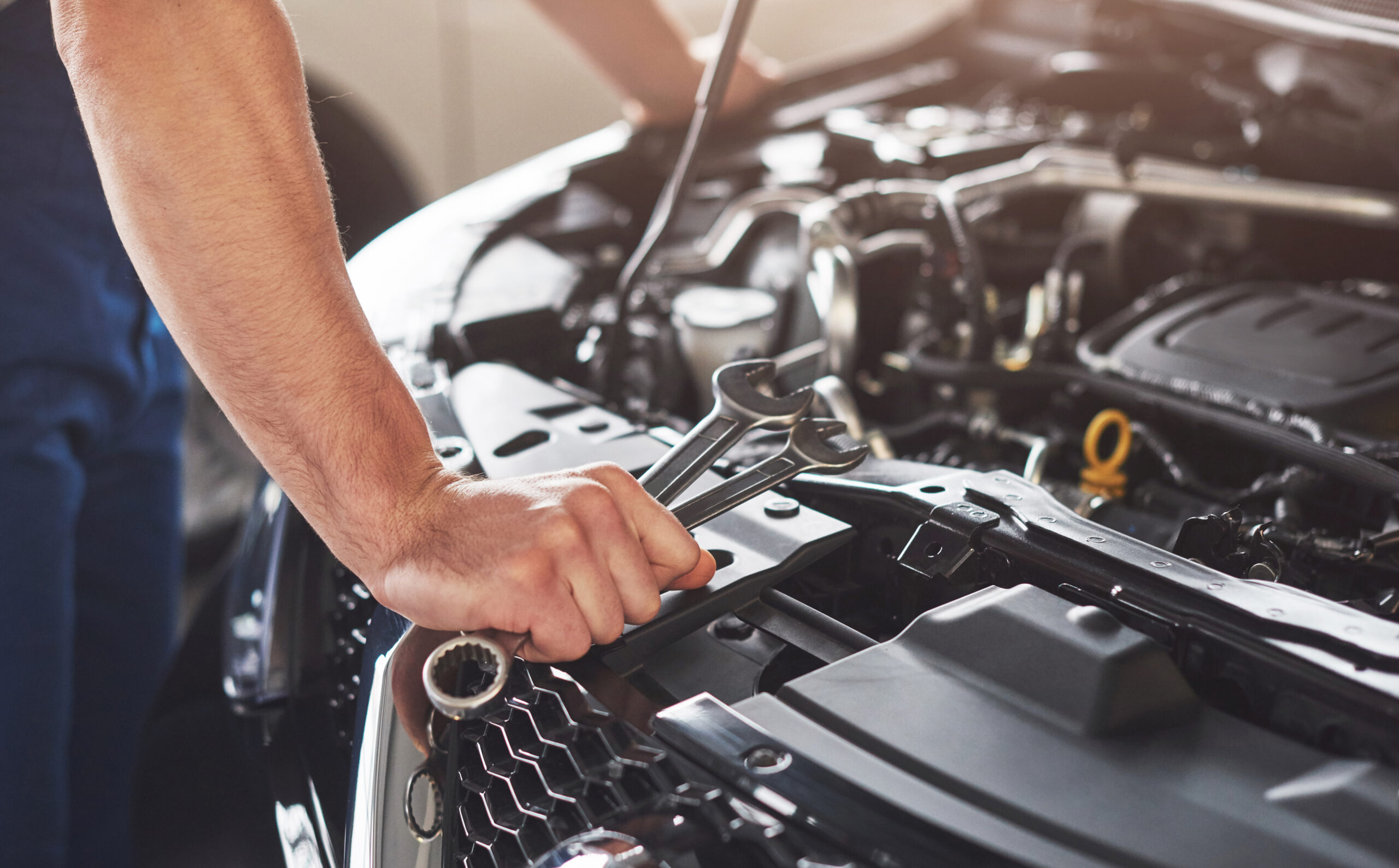Muscular car service worker repairing vehicle